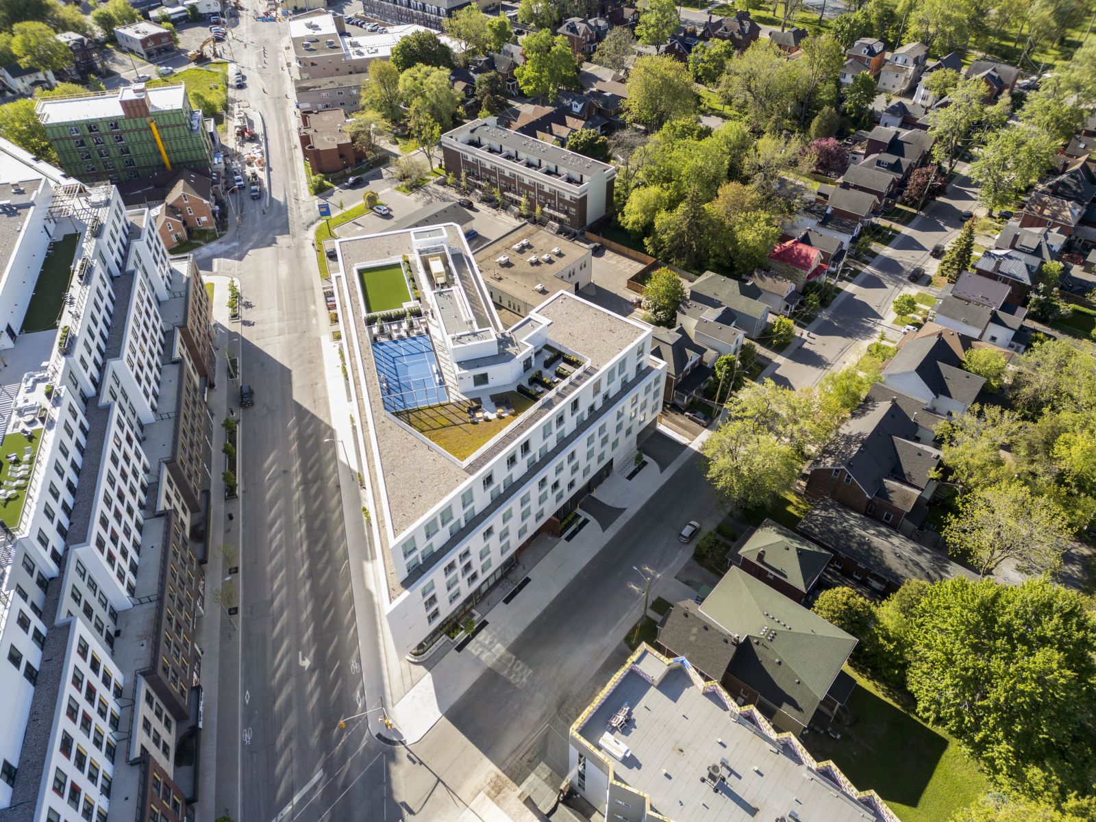 Aerial view of GEOpark with rooftop pool, sport court, and surrounding city neighborhood.