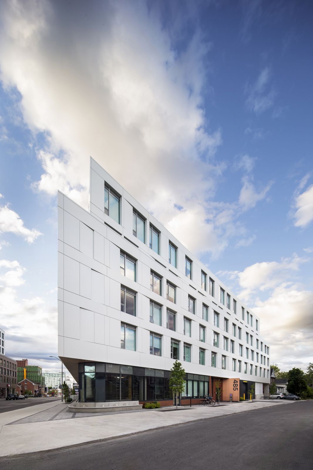 GEOpark white apartment building exterior viewed from the street under a partly cloudy sky.